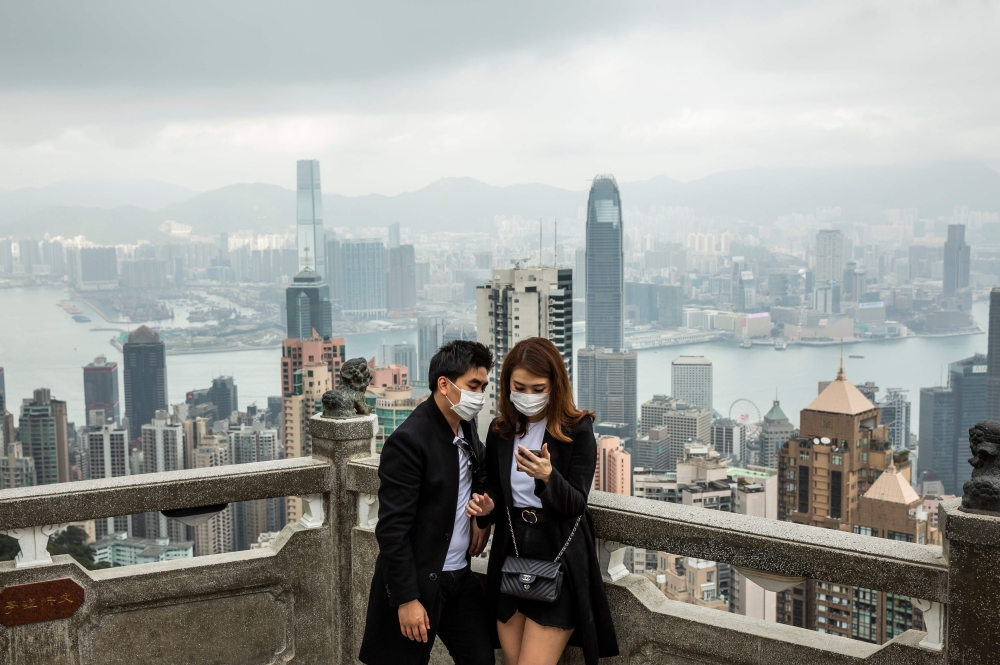People wearing protective face masks visit the lookout of Victoria Peak in Hong Kong on February 25, 2020. AFP / Isaac Lawrence