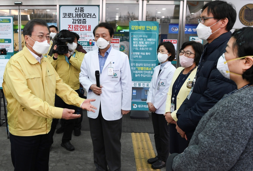 South Korea's President Moon Jae-in gets briefed during his visit to a medical center in Daegu, South Korea, February 25, 2020. Yonhap via REUTERS