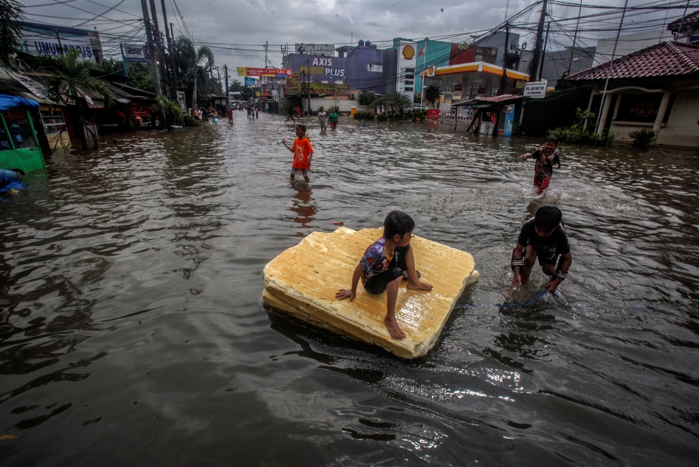 Children play in the floodwaters after heavy rains in Bekasi, near Jakarta, Indonesia February 25, 2020 in this photo taken by Antara Foto. Antara Foto/Yulius Satria Wijaya/ via REUTERS