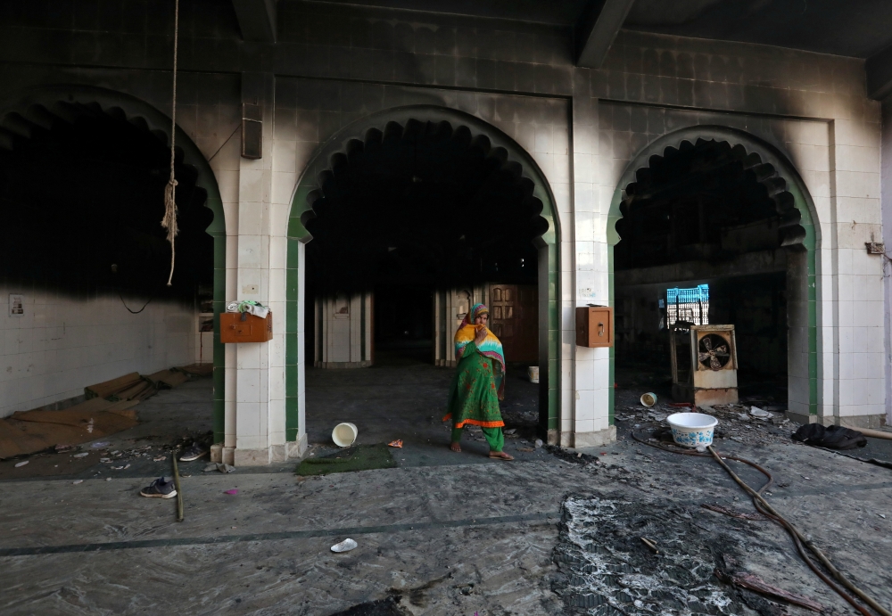 A woman walks inside a partially damaged mosque after it was set on fire by a mob in a riot affected area after clashes erupted between people demonstrating for and against a new citizenship law in New Delhi, India, February 26, 2020. Reuters/Rupak De Cho