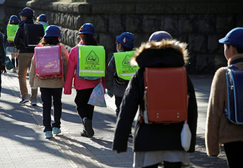  Elementary school students walk toward their school in Tokyo, Japan, February 28, 2020. REUTERS/Issei Kato 