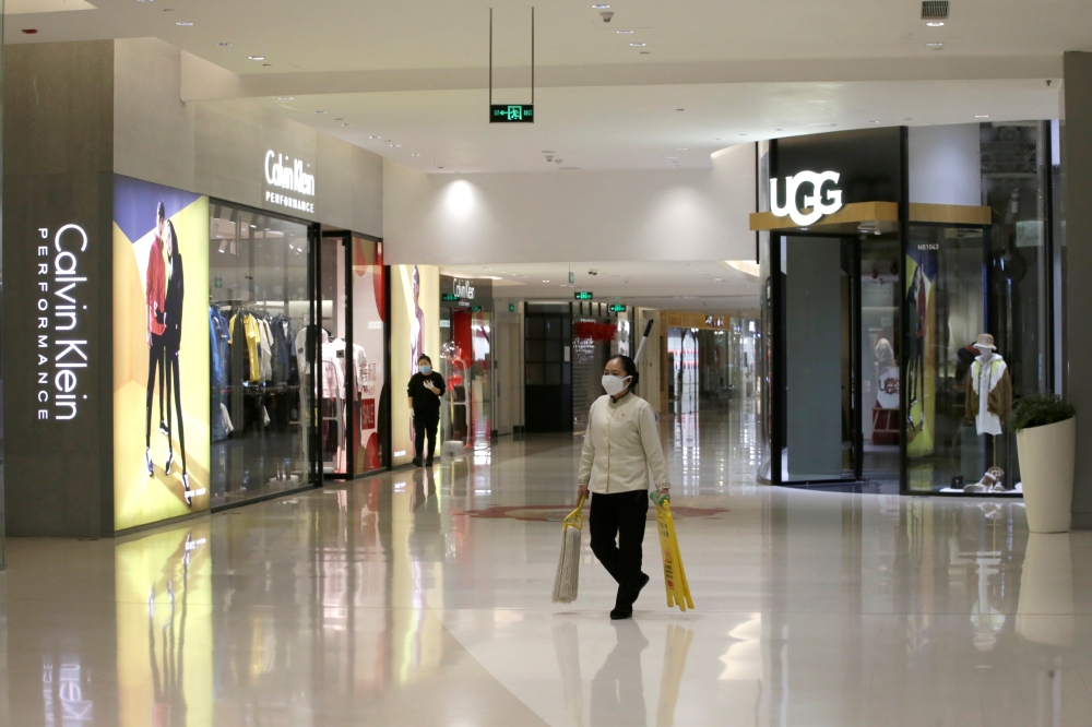 A cleaner worker wearing a mask walks at a shopping mall in central business area, Beijing China, as the country is hit by an outbreak of the new coronavirus, February 2, 2020. Reuters / Jason Lee
