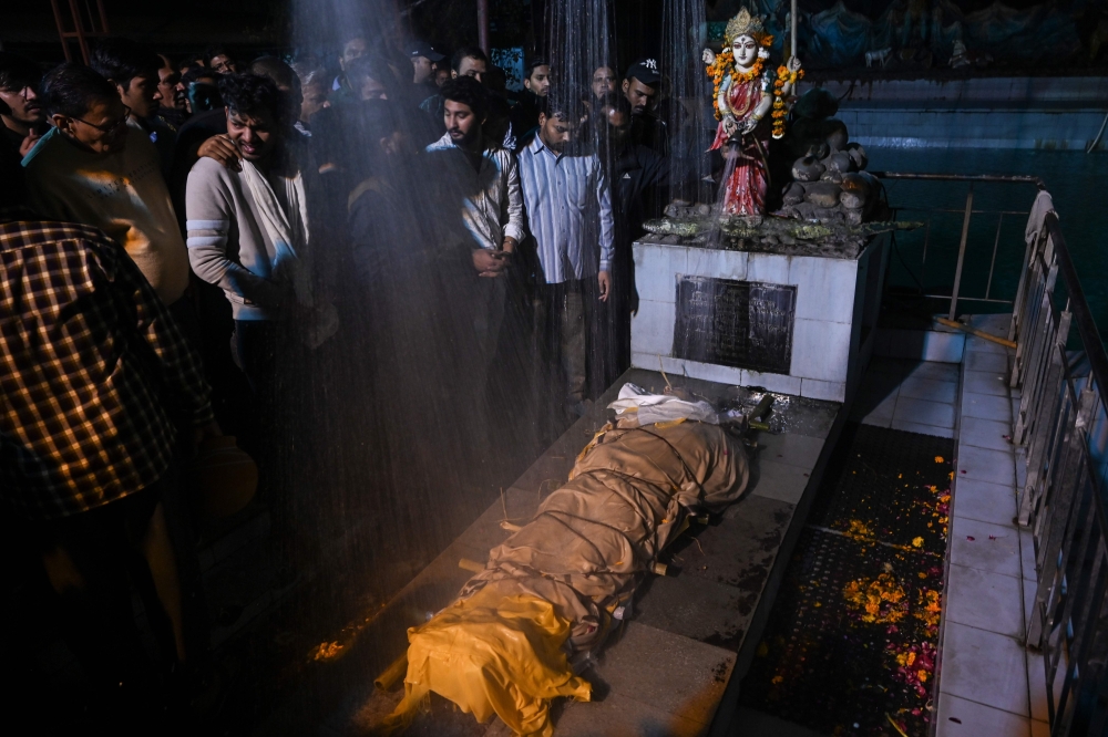 Relatives and friends of Rahul Thakur, 23, who died in this week's sectarian riots in India's capital over Prime Minister Narendra Modi's citizenship law, stand around his body before its cremation in New Delhi February 27, 2020. AFP / Money SHARMA 
 