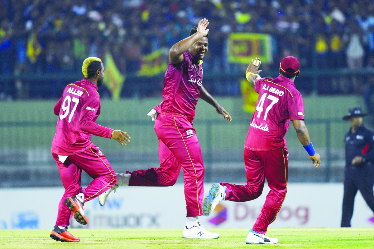 West Indies' Oshane Thomas (C) celebrates with his teammates after dismissing Sri Lanka's Angelo Mathews during the first Twenty20 international cricket match of a two-match series between Sri Lanka and West Indies at the Pallekele International Cricket S