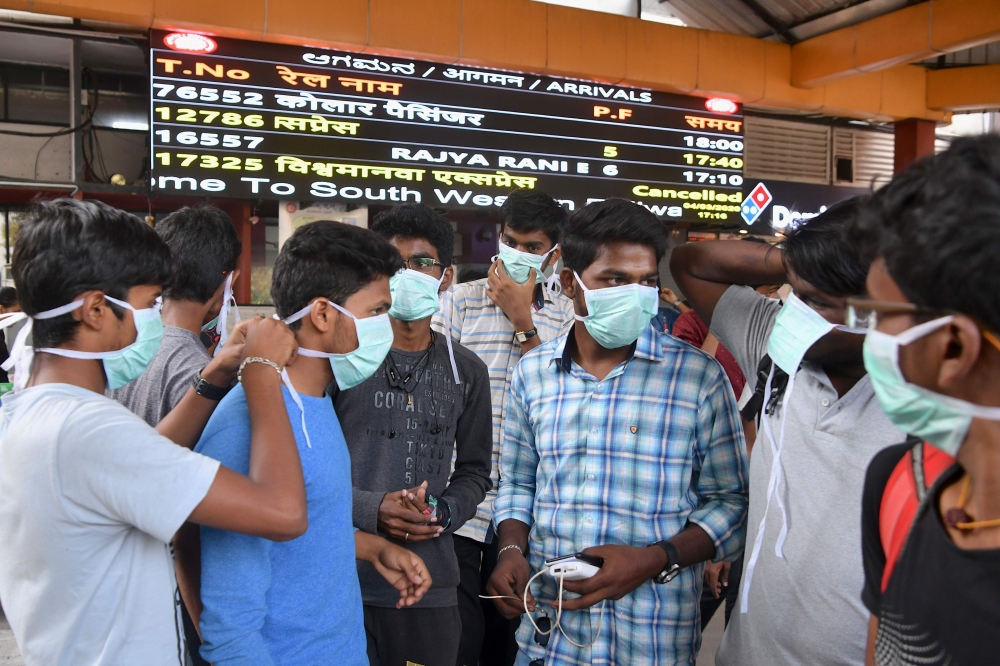 Young tourists wear facemasks as a preventive measure against the spread of the COVID-19 coronavirus outbreak at the Bangalore City Railway Station, on March 4, 2020. AFP / Manjunath Kiran