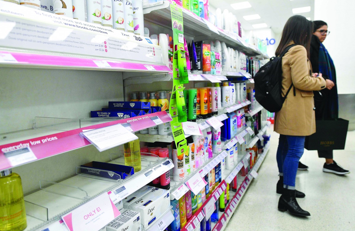 A picture shows a sign, on empty shelves, alerting customers to limited sales of antibacterial hand washes and sanitiser gels, inside a Boots store in London on March 3, 2020.  AFP / Justin Tallis
 