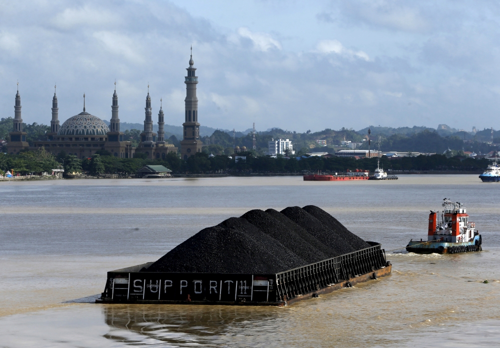 A tug boat pulls a coal barge along the Mahakam River in Samarinda, East Kalimantan province, Indonesia, March 2, 2016. Reuters/Beawiharta