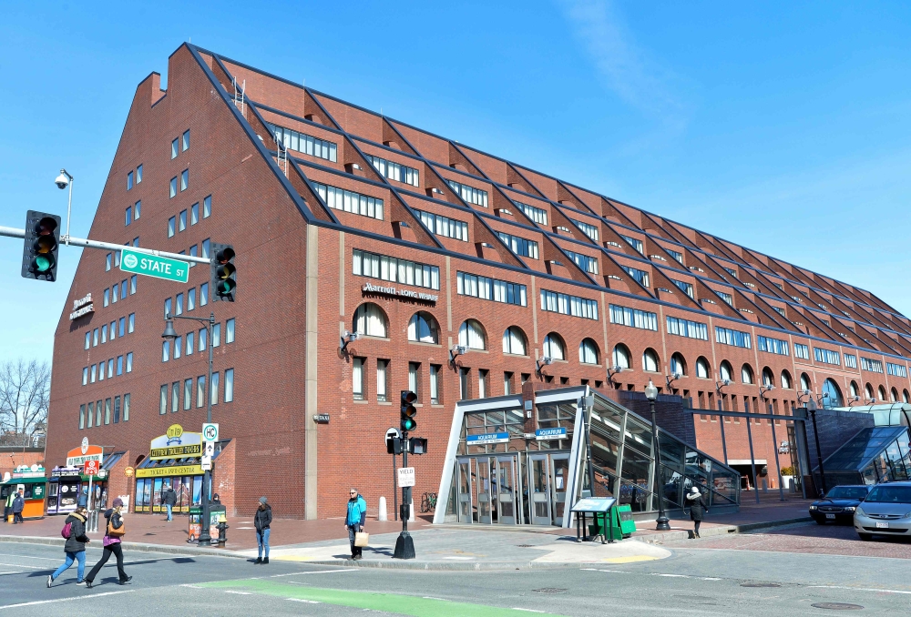 People walk past the Marriot Long Wharf Hotel in Boston, Massachusetts on March 7, 2020. The day before 60 hotel guests who attended a Biogen conference at the hotel were taken to be tested for coronavirus at Brigham and Women's Hospital.  AFP / Joseph Pr