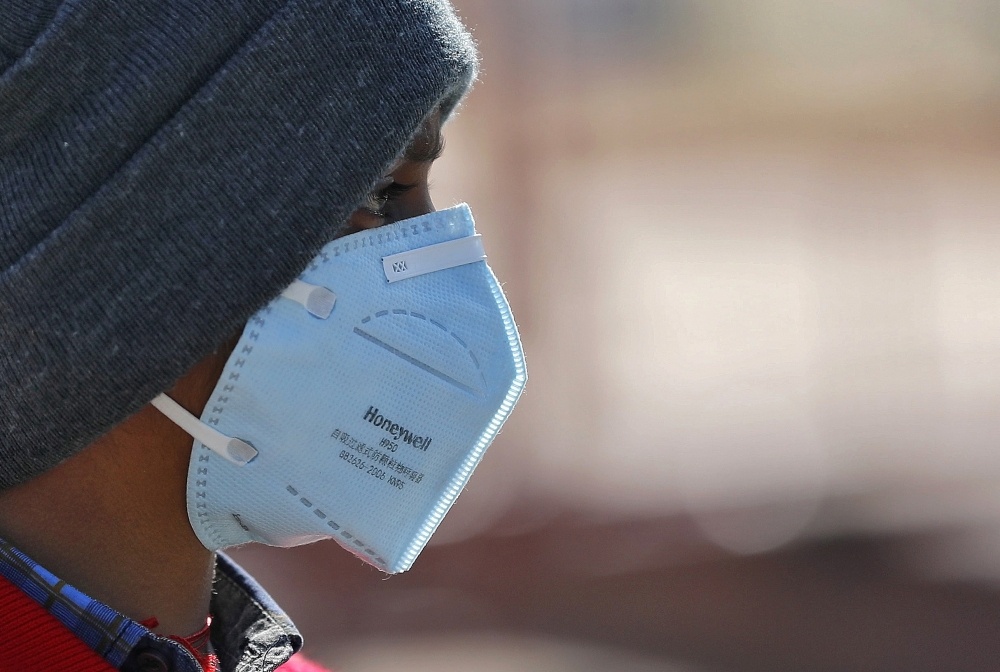 A boy wearing a protective mask walks in a street following an outbreak of the coronavirus disease, in New Delhi, India, March 9, 2020. REUTERS/Adnan Abidi