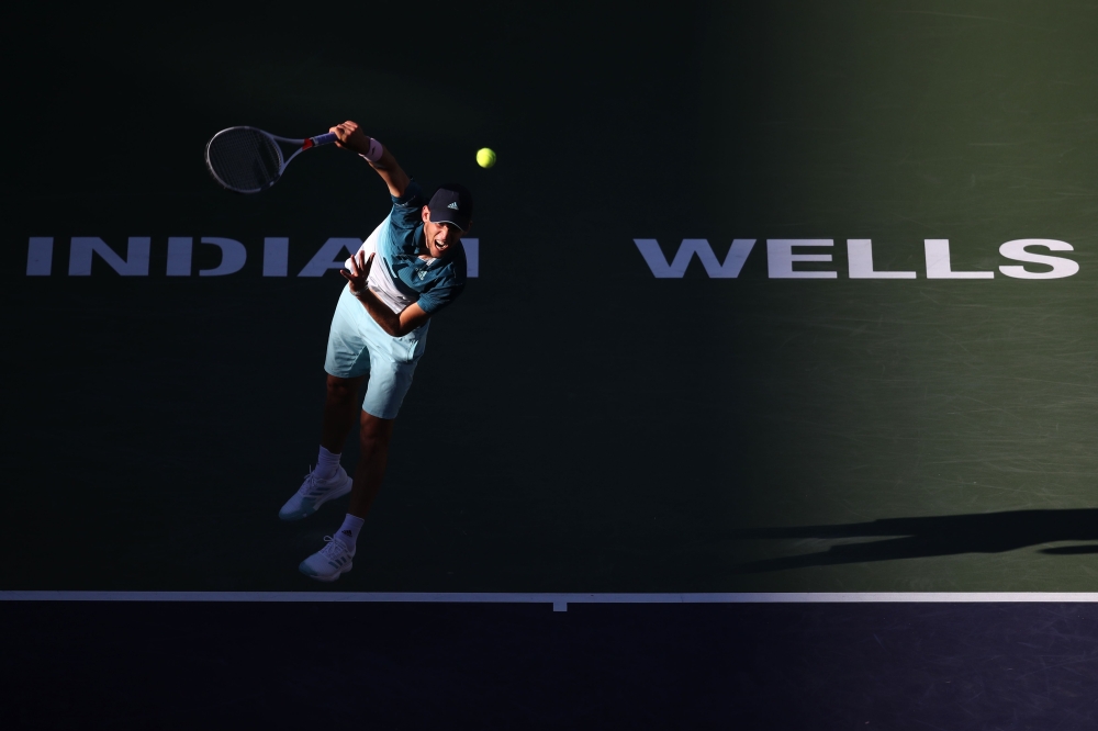 (FILES) In this file photo taken on March 16, 2019 Dominic Thiem of Austria serves against Roger Federer of Switzerland during their men's singles final match at the BNP Paribas Open at the indian Wells tennis Garden on March 17, 2019 in Indian Wells, Cal