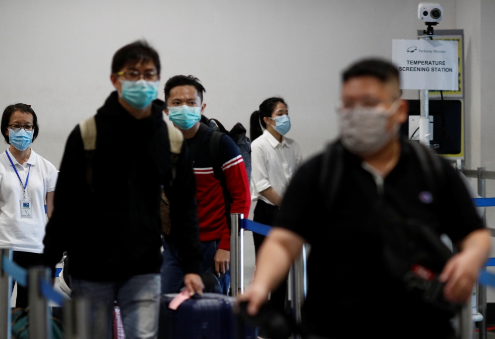 Passengers arriving from Batam, Indonesia, pass a temperature screening station at the Singapore Cruise Center, following the coronavirus outbreak in Singapore March 5, 2020. REUTERS/Edgar Su 