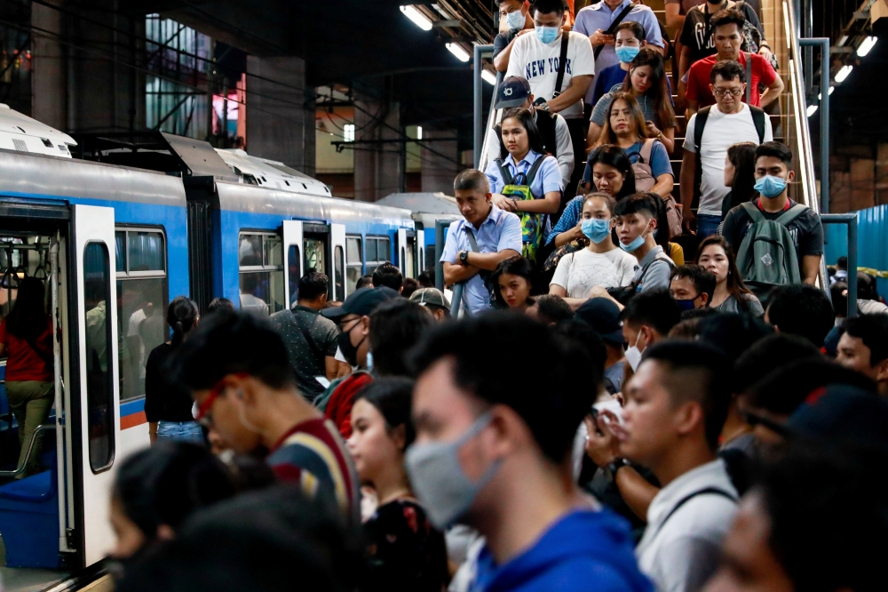 Commuters wear protective face masks as they queue to get into a train amid new cases of coronavirus in Manila, Philippines, March 11, 2020. REUTERS/Eloisa Lopez