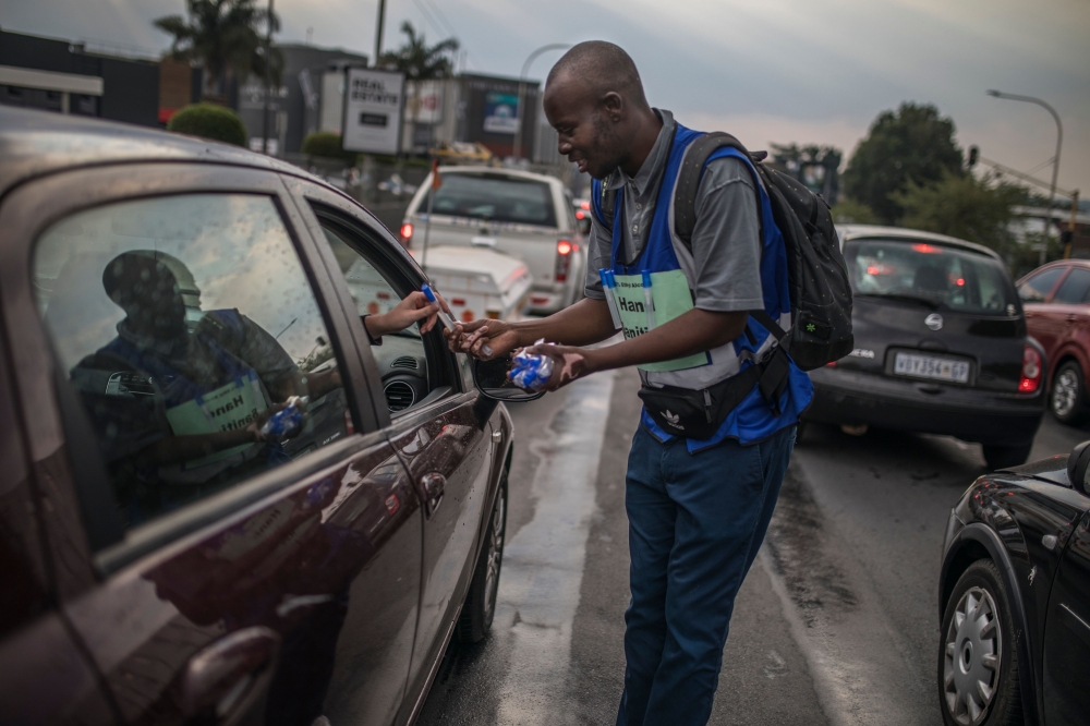 Tshepo Mabasa, 33, walks among cars selling hand sanitizers for 20 rand (1,10 euros) in Johannesburg, on March 11, 2020, amid the outbreak of COVID-19, the new coronavirus. South Africa has registered 13 cases of the new coronavirus. / AFP / Guillem Sarto