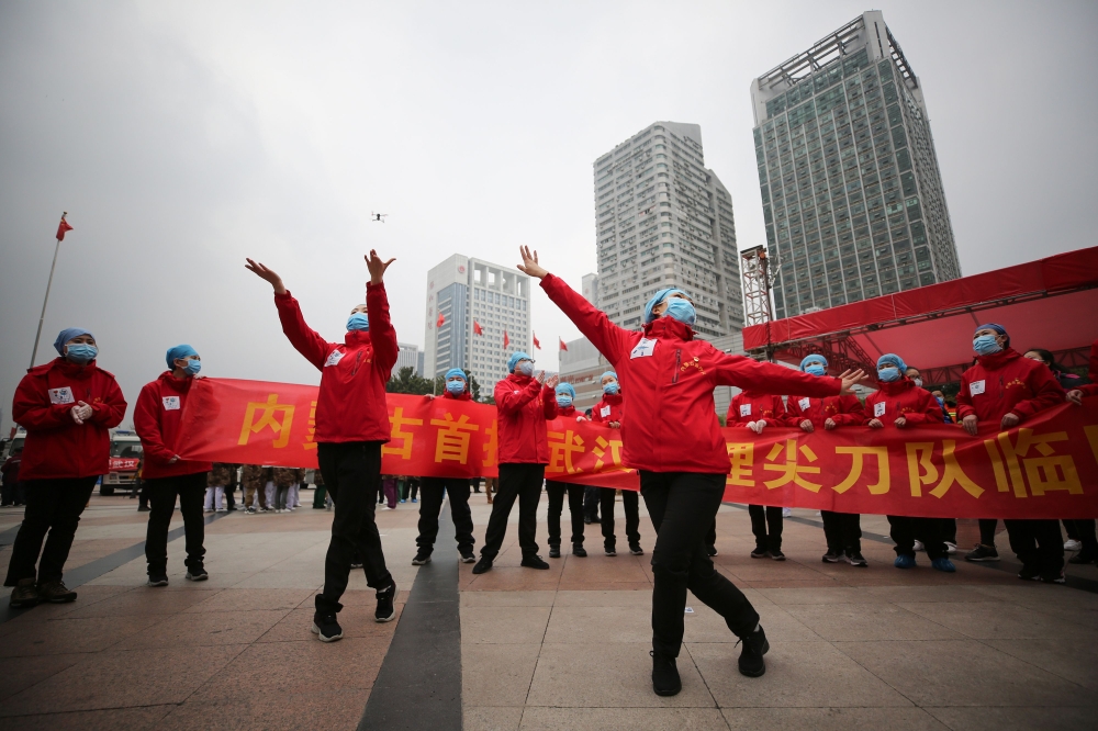 TOPSHOT - Medical staff celebrate after all patients were discharged at a temporary hospital set up to treat people with the COVID-19 coronavirus in Wuhan in China's central Hubei province on March 9, 2020. / AFP / STR
