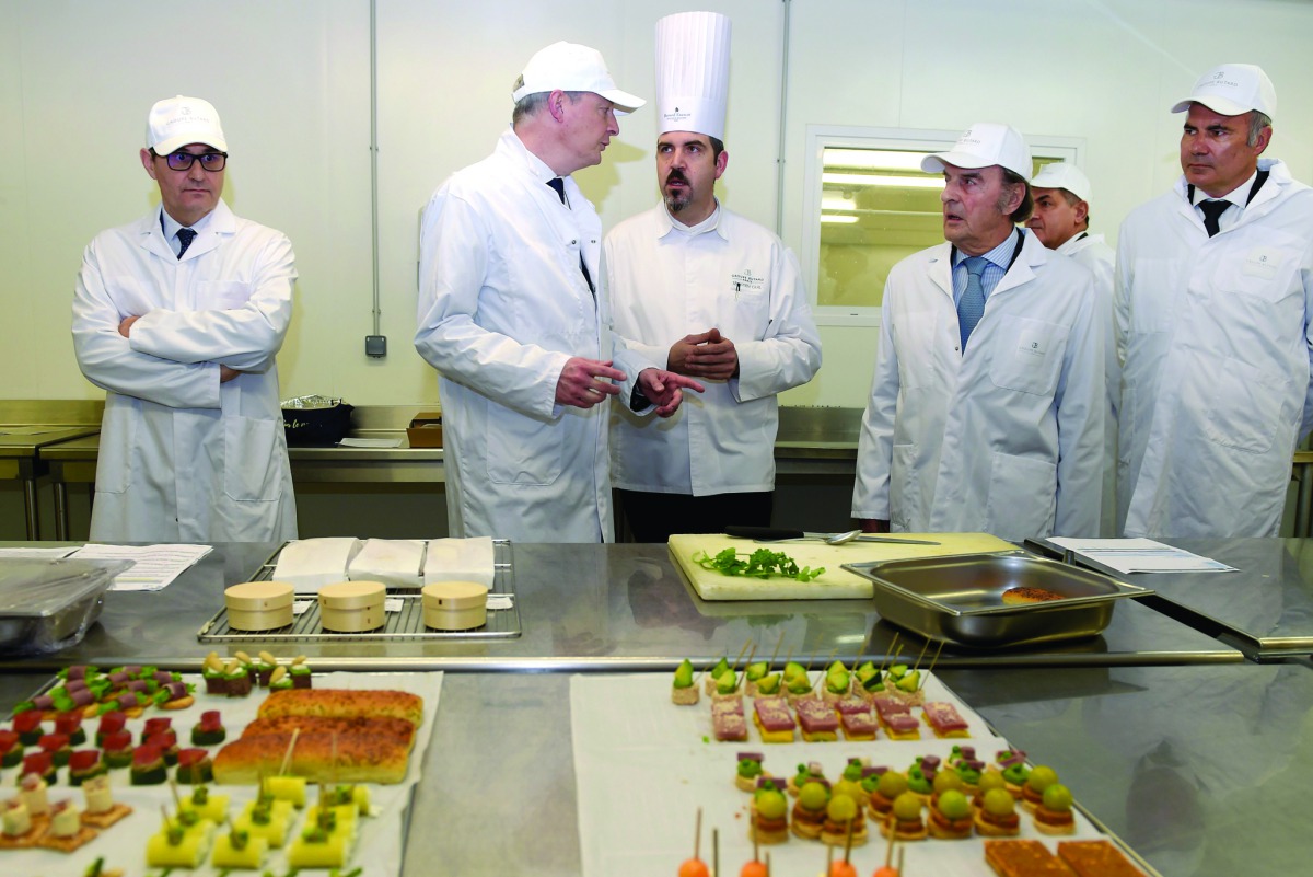 French Economy and Finance Minister Bruno Le Maire (2ndL) chats with employees as he visits the French catering group Butard Enescot to talk about the consequences of the COVID-19 outspread on companies working for events in Colombes, near Paris on March 