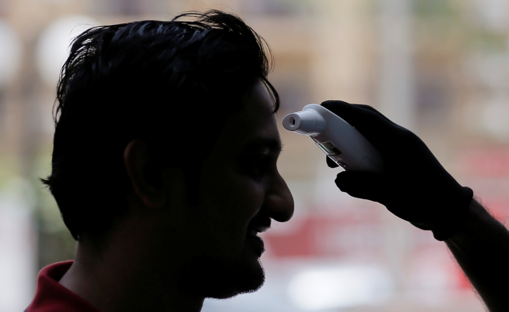A man is checked with a thermal scanner by officers at World Trade Center, after the first case with the coronavirus was detected, in Colombo, Sri Lanka March 12, 2020. REUTERS/Dinuka Liyanawatte
