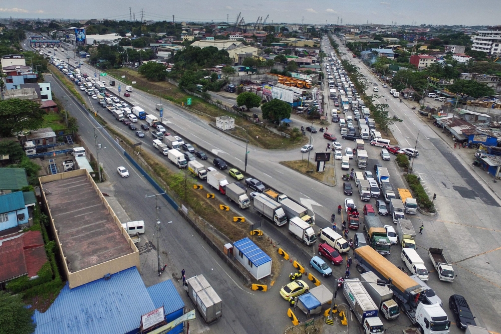 This aerial photo shows traffic congestion from vehicles waiting to clear checkpoints, part of measures to reduce the spread of the COVID-19 pandemic, before entering Manila on March 16, 2020. AFP / Ron LOPEZ