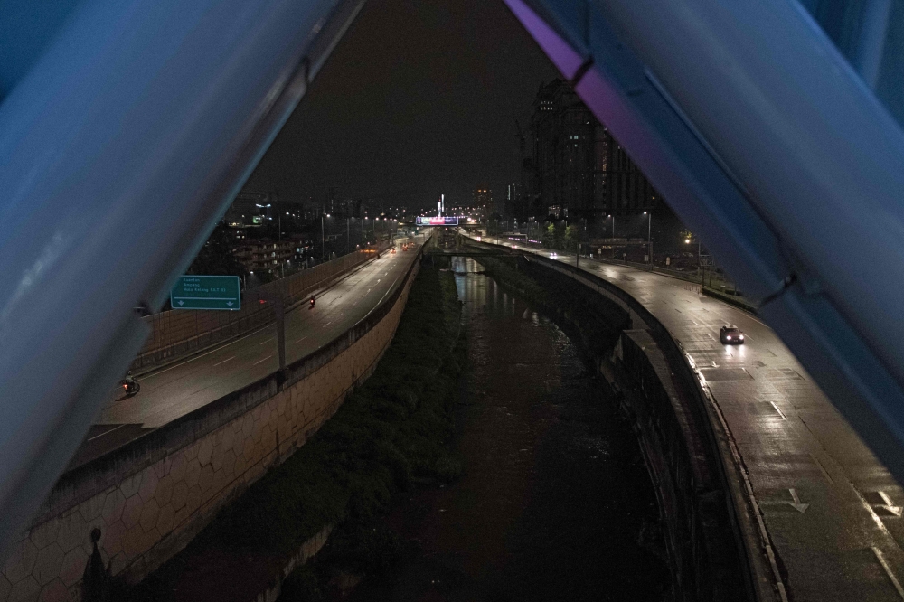 Motorists travel on the near-deserted Ampang-Kuala Lumpur Elevated Highway on the eve before Malaysia imposes a lockdown on travel amid fears over the spread of the COVID-19 coronavirus, in Kuala Lumpur on March 17, 2020. / AFP / Mohd RASFAN