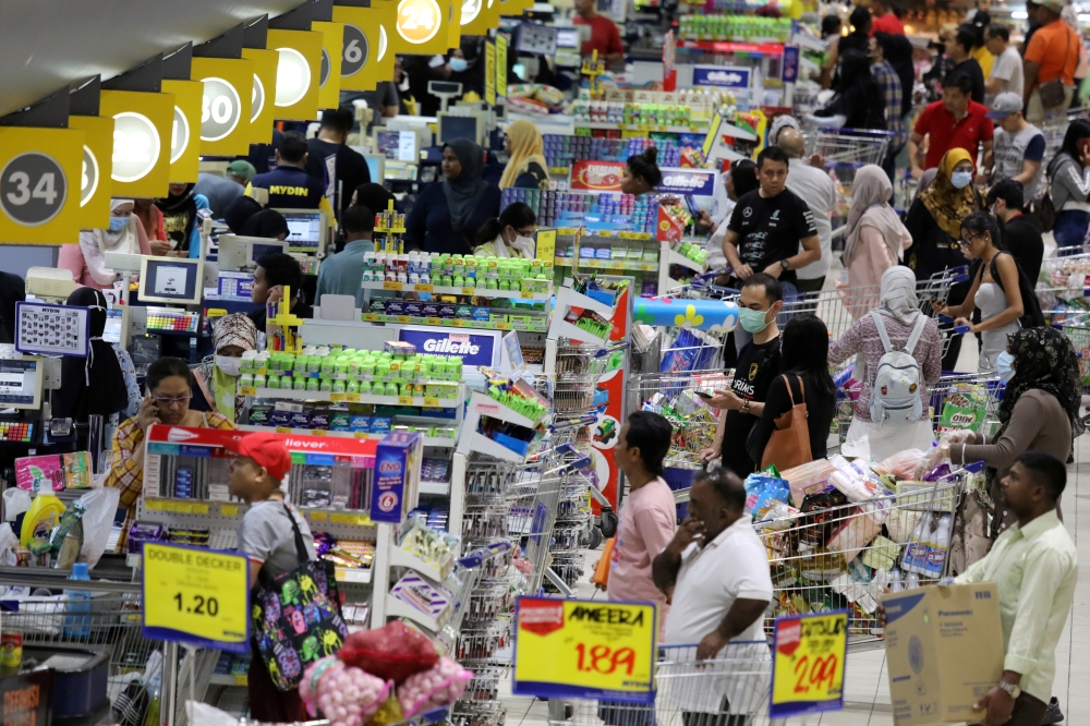 People line up to pay at a supermarket amid fears of a disruption in supplies after the Malaysia's government announces a restricted movement order imposed on March 18 due to the spread of the coronavirus disease, in Subang Jaya, Malaysia, March 17, 2020.