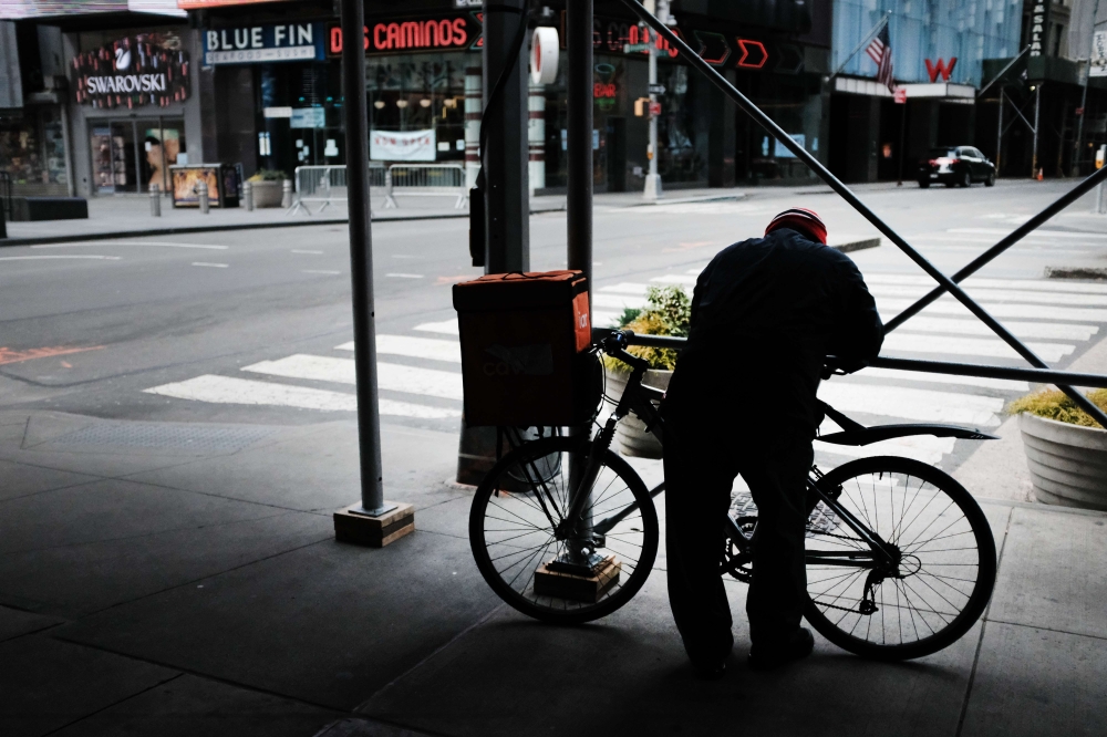  A delivery man pauses in an empty Times Square as much of the city is void of cars and pedestrians over fears of spreading the coronavirus on March 22, 2020 in New York City. Spencer Platt/Getty Images/AFP
