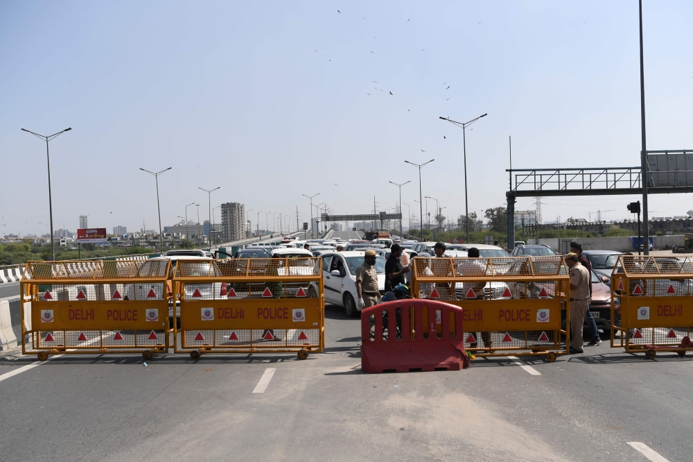 Incoming traffic to Delhi is stopped by policemen at a checkpoint at the Uttar Pradesh and Delhi border along the Delhi-Meerut Expressway to inforce a lockdown order by Delhi's government as a preventive measure against the COVID-19 novel coronavirus, in 