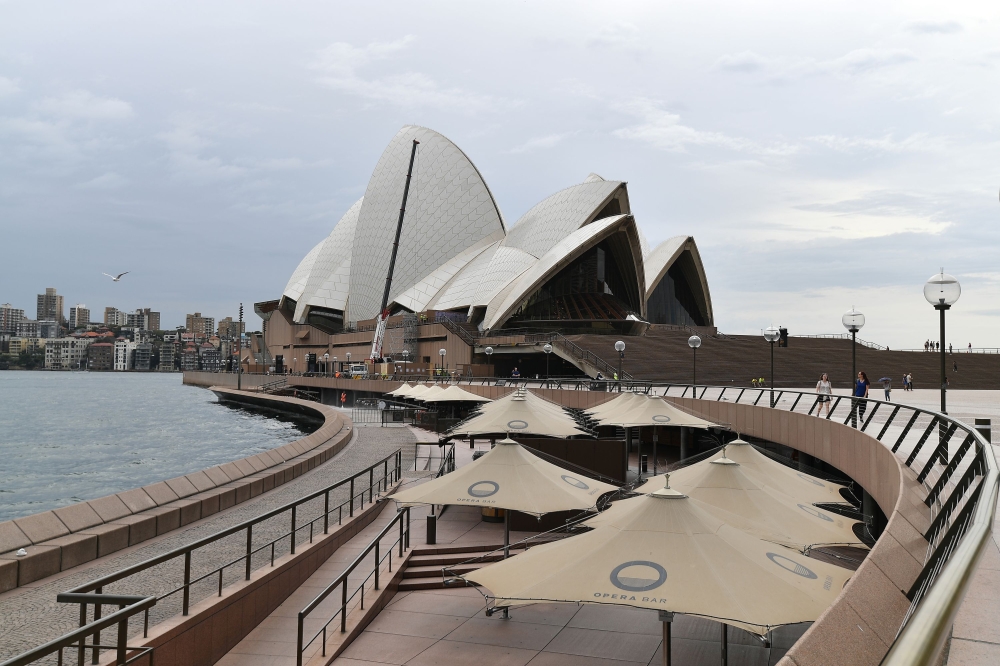 A seating area (below) normally filled with tourists remains empty along Circular Quay in Sydney on March 25, 2020, as people stay away due to restrictions to stop the spread of the worldwide COVID-19 coronavirus outbreak. / AFP / Saeed KHAN