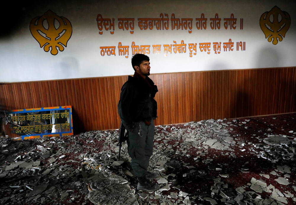 An Afghan policeman inspects inside a Sikh religious complex after an attack in Kabul, Afghanistan March 25, 2020.REUTERS/Mohammad Ismail