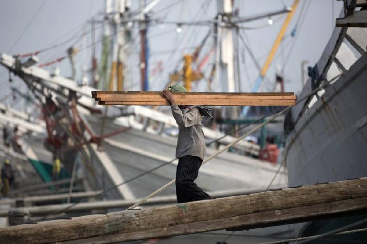 A labourer unloads timber from Kalimantan province at Sunda Kelapa port in Jakarta, September 8, 2014. Reuters/Darren Whiteside 