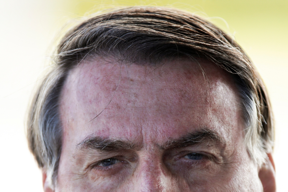 Brazil's President Jair Bolsonaro meets supporters as he leaves Alvorada Palace, as the COVID-19 spread continues, in Brasilia, Brazil March 30, 2020. Reuters/Ueslei Marcelino
 
 
  
 