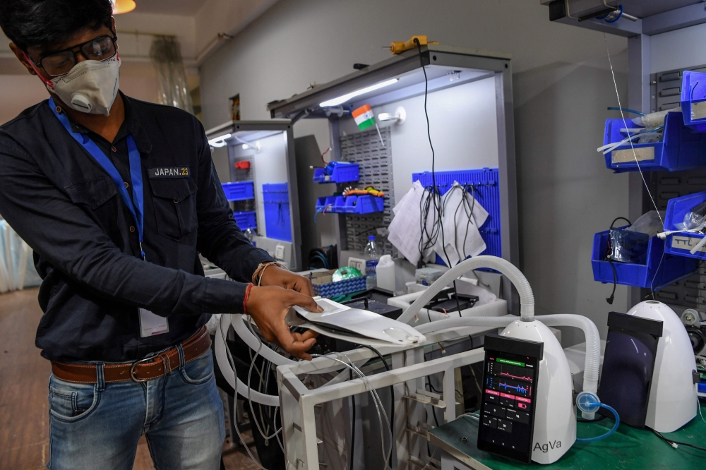 In this photo taken on March 25, 2020, AgVa Healthcare employee Vaibhav Gupta demonstrates using a ventilator at the research and development (R&D) centre in Noida in Uttar Pradesh state. AFP / Prakash Singh  