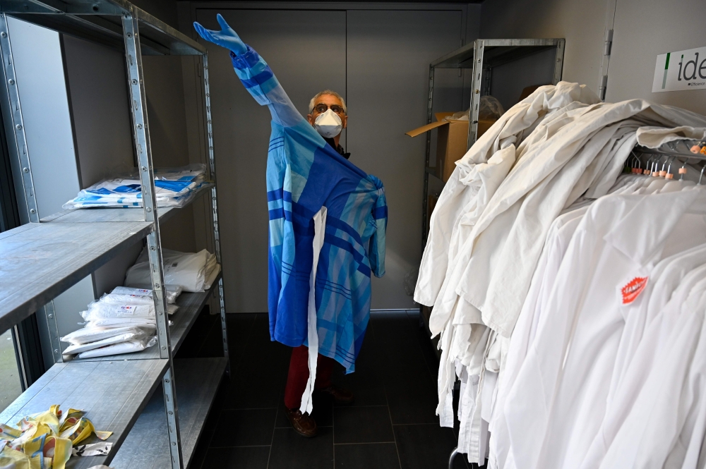 A doctor wears a homemade Tie-Back Surgical Gown in a consultation centre dedicated to COVID-19, the disease caused by the novel coronavirus, suspected patients in Tinteniac, western France on March 27, 2020. AFP / Damien Meyer