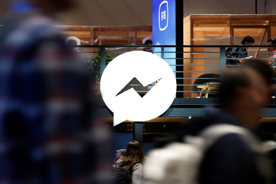 FILE PHOTO: Attendees walk past a Facebook Messenger logo during Facebook Inc's annual F8 developers conference in San Jose, California, U.S. May 1, 2018. REUTERS/Stephen Lam