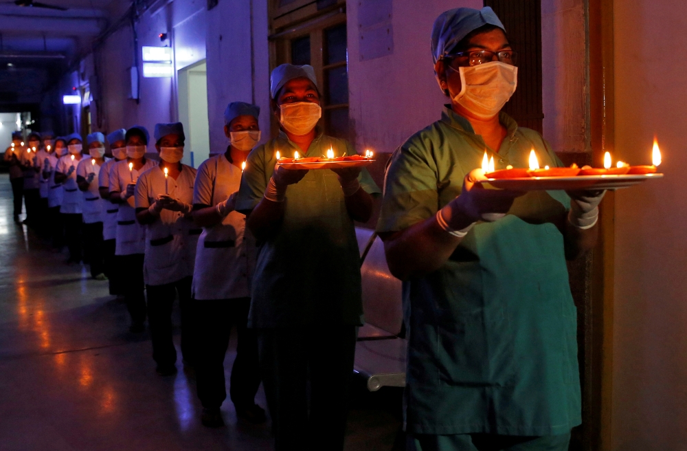 Staff members of a hospital carry candles and oil lamps to show solidarity with people who are affected by the coronavirus disease (COVID-19), and with doctors, nurses and other healthcare workers from all over the world during a 21-day nationwide lockdow