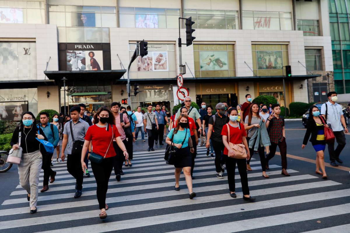 Pedestrians wearing protective face masks cross a street outside a shopping mall amid new cases of coronavirus, in Manila, Philippines, March 11, 2020. REUTERS/Eloisa Lopez