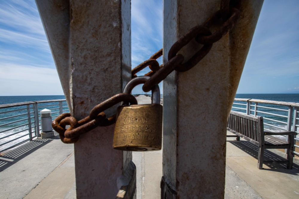 In this file photo taken on March 21, 2020, alocked pier closed to the public is pictured in Hermosa Beach, California. Another 6.6 million US workers file for unemployment benefits for the week ending April 4, 2020, the Labor Department said on April 9, 