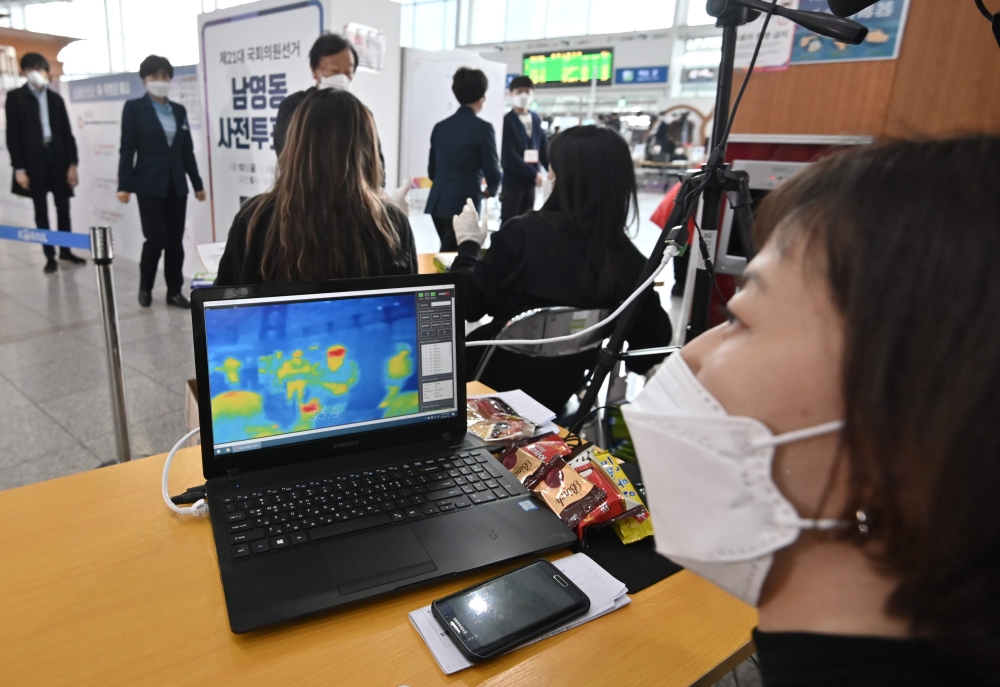 A thermal camera system monitors the body temperature of people during early voting at a polling station in Seoul on April 10, 2020, ahead of next week's parliamentary elections. AFP / Jung Yeon-je