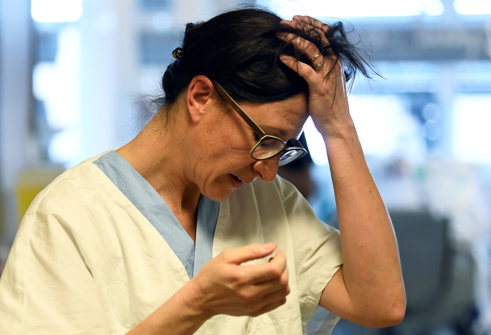 A medical staff member reacts in the intensive care unit, where patients suffering from the coronavirus disease (COVID-19) are treated, at the Circolo hospital in Varese, Italy April 9, 2020. REUTERS/Flavio Lo Scalzo
