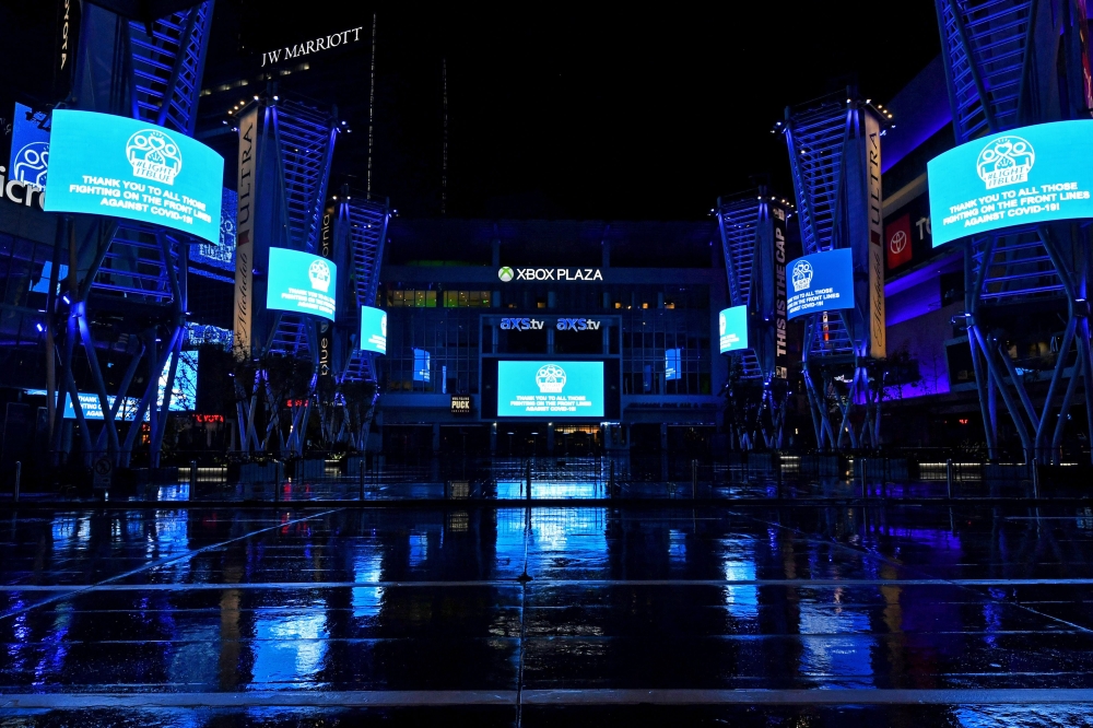 :LOS ANGELES, - APRIL 09: L.A. Live is illuminated in blue lights during the coronavirus pandemic on April 09, 2020 in Los Angeles, United States. Landmarks and buildings across the nation are displaying blue lights to show support for health care workers