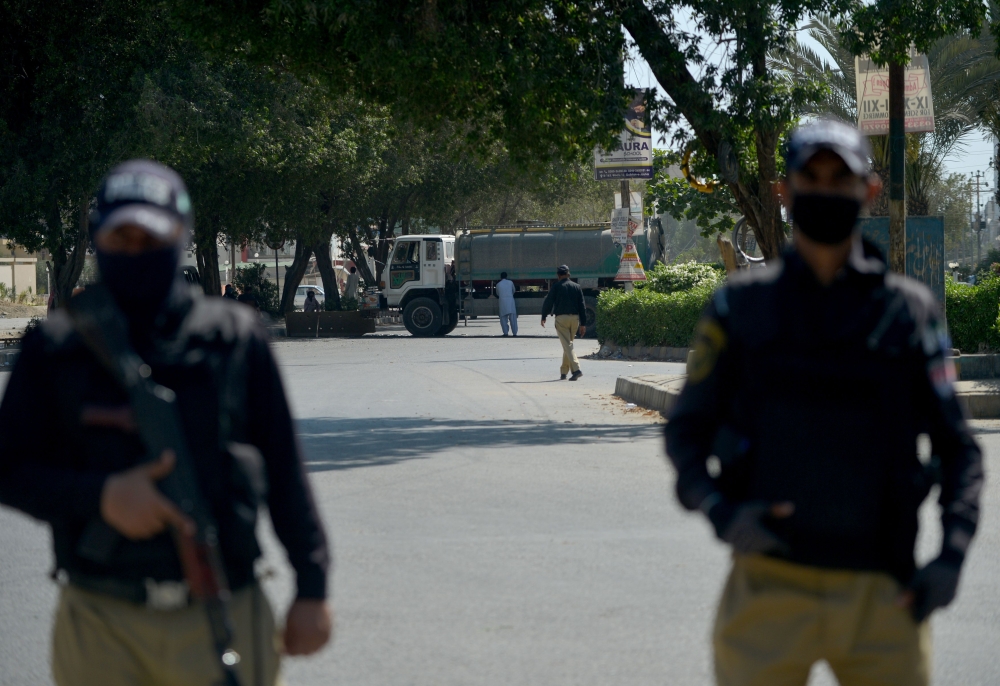 Policemen stand guard after cordoning an area during a government-imposed nationwide lockdown as a preventive measure against the COVID-19 coronavirus, in Karachi on April 12, 2020. / AFP / Rizwan TABASSUM