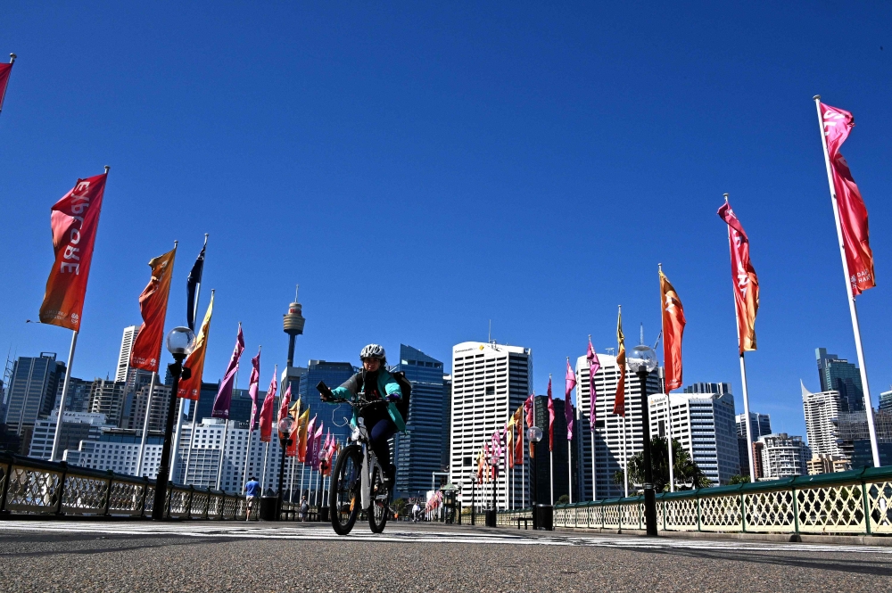 A food delivery courier makes her way down an empty area of central Sydney on April 15, 2020. / AFP / Saeed KHAN