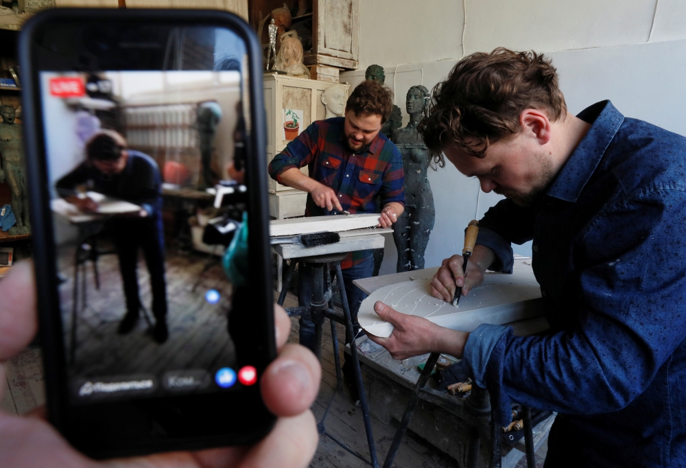 Ukrainian contemporary artists, brothers Nikita and Egor Zigura work in their workroom during an online auction in Kiev, Ukraine, April 13, 2020. Picture taken April 13, 2020. REUTERS/Gleb Garanich