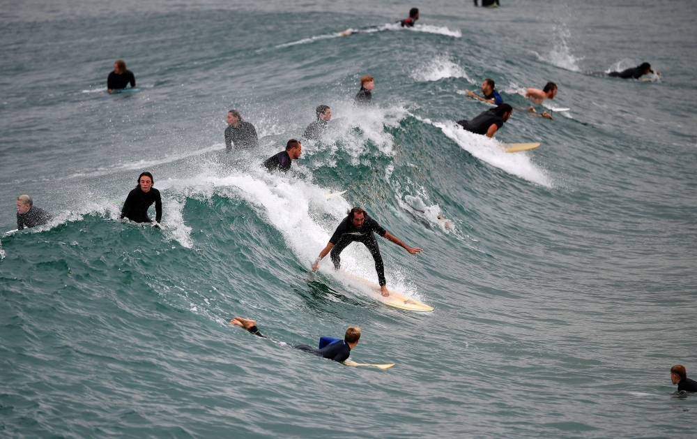 People surf at Maroubra Beach in Sydney on April 20, 2020. Authorities in Sydney reopened three beaches for walking, running, swimming or surfing only amid lockdown restrictions put in place due to the COVID-19 coronavirus outbreak. / AFP / Saeed KHAN
