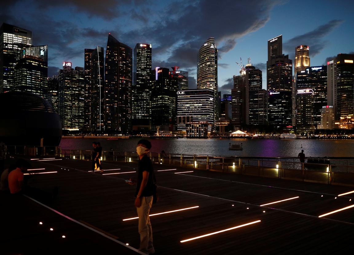 file photo: A man wearing a mask in precaution of the coronavirus looks on along the Marina Bay Waterfront Promenade in Singapore February 19, 2020. REUTERS/Edgar Su