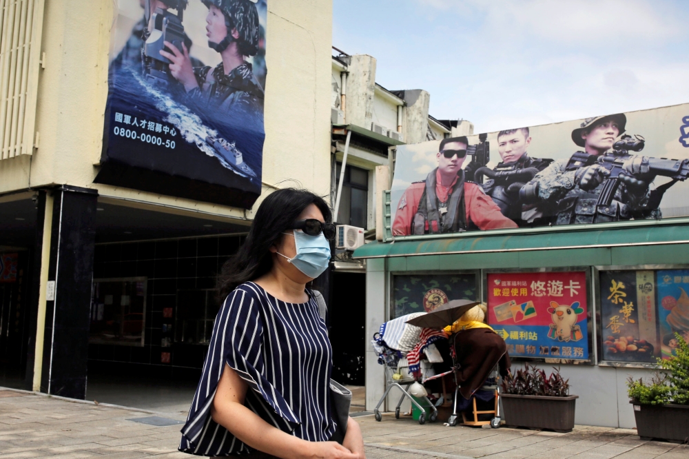 A woman, wearing a protective face mask, walks past Ministry of National Defense recruitment posters, amid concerns about the coronavirus disease (COVID-19), in Taipei, Taiwan, April 20, 2020. REUTERS/Ann Wang