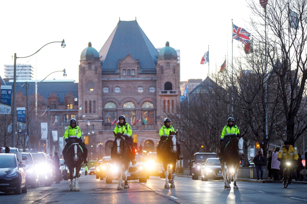 Mounted police officers ride down University Ave. through hospital row as Toronto first responders parade in front of the hospitals in Toronto, Ontario, Canada, in a salute to healthcare workers on April 19, 2020, amid the novel coronavirus pandemic. T/ A