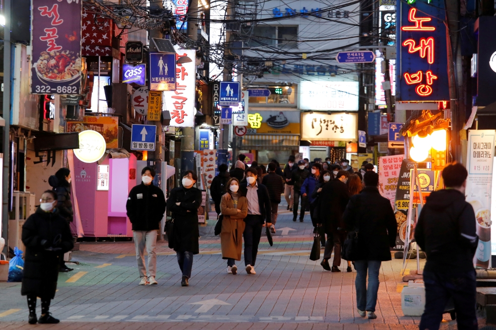 FILE PHOTO: People wearing face masks to protect themselves against contracting the new coronavirus walk on a street in central Seoul, South Korea April 22, 2020. REUTERS/Heo Ran/File Photo
