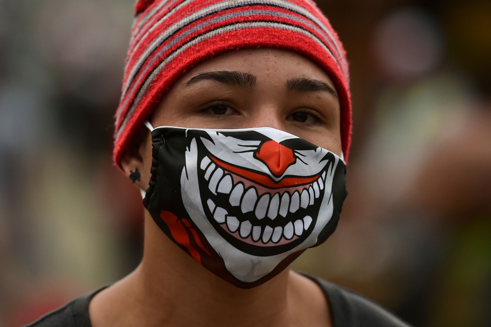 A woman wears a face mask as a preventive measure against the spread of the novel coronavirus, COVID-19, on April 24, 2020, at Santa Elena market in Cali, Colombia. / AFP / Luis ROBAYO