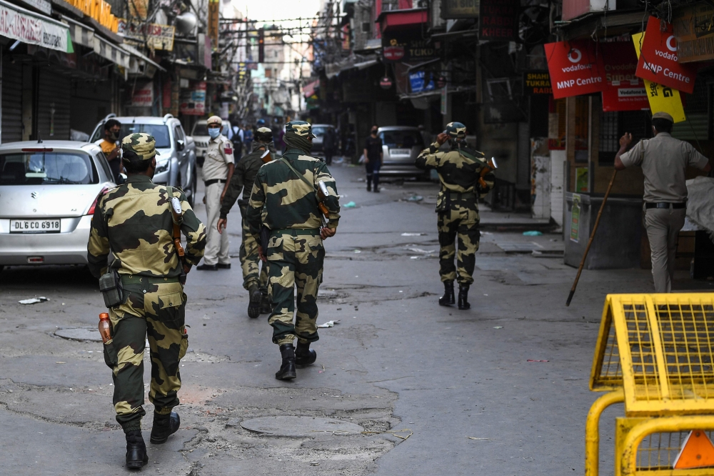 Border Security Force personnel (BSF) patrol a deserted street during a government-imposed nationwide lockdown as a preventive measure against the spread of the COVID-19 coronavirus, in the old quarters of New Delhi on April 25, 2020. / AFP / SAJJAD HUSSA