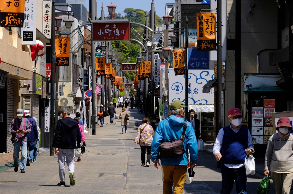 People walk along a shopping street leading to Tsuruoka Hachimangu, a symbolic shrine in Kamakura on April 25, 2020, amid concerns of the COVID-19 coronavirus. / AFP / Kazuhiro NOGI
