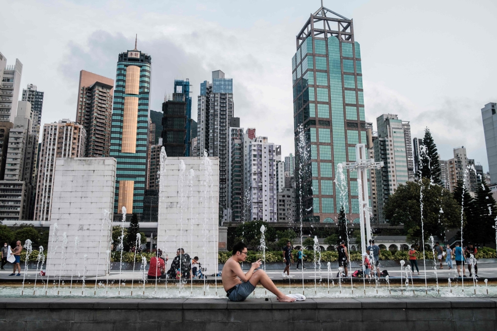 (FILES) In this file photo taken on April 21, 2020, a man sits next to a fountain at the Sun Yat Sen Memorial Park in Hong Kong. As Hong Kongers hunker down during the coronavirus pandemic, police have ramped up arrests of pro-democracy activists while Be